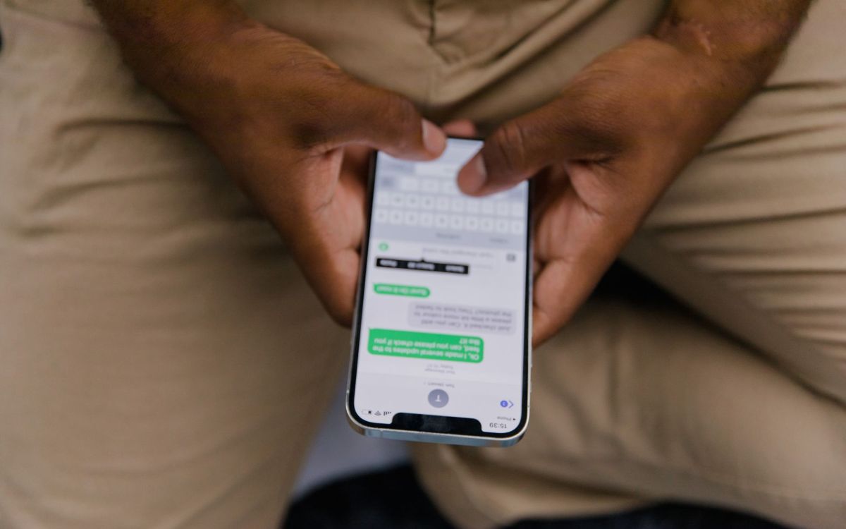 Mãos digitando uma conversa no celular
